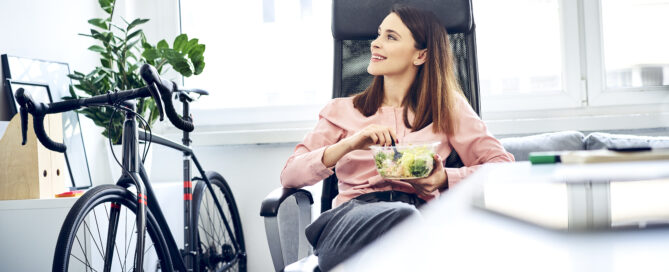 woman at work embracing wellness with a bike and salad