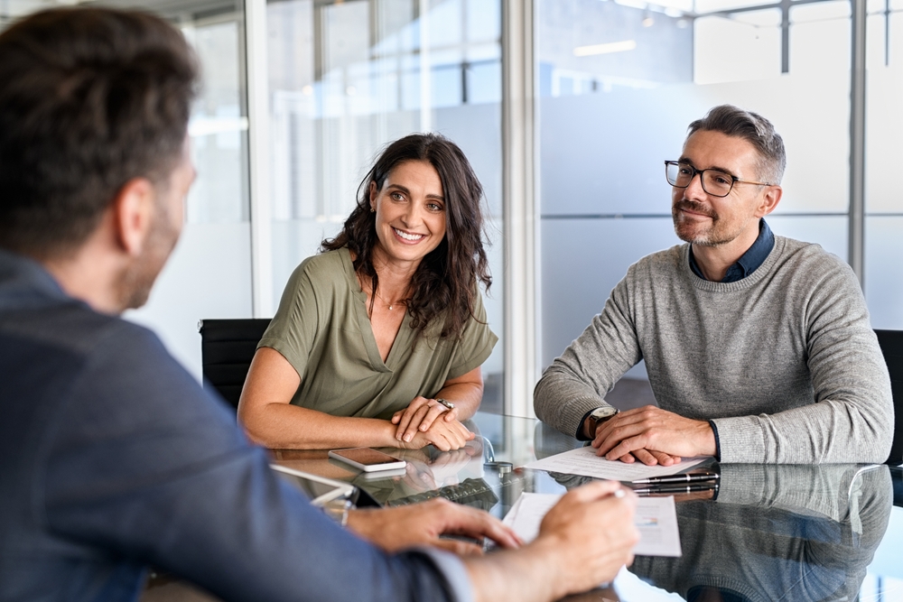 Smiling,Mature,Couple,Meeting,With,Bank,Manager,For,Investment.,Mid Arizona Group Retirement Planning Advisor
