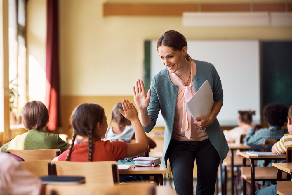 Happy,Elementary,School,Teacher,Giving,High-five,To,Her,Student,During Employee Benefits Education and Teaching